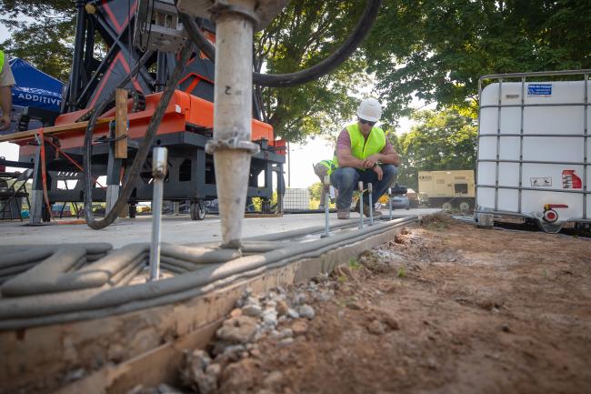 Eric Wooldridge examines the precision layering of concrete during the early stages of Kentucky’s first 3D-printed house, completed by his team in Somerset in June